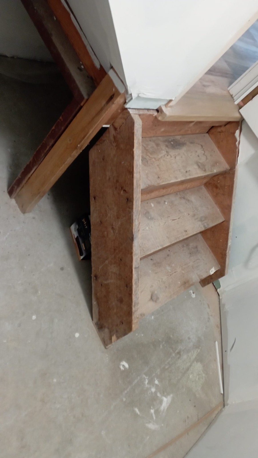 Basement stairs with raw wood treads during a structural rebuild