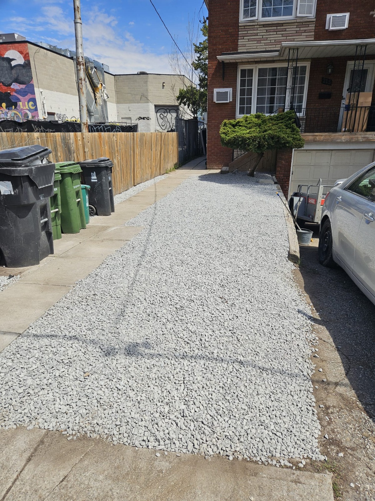 Fresh white-gravel driveway laid between a home and the neighbouring property