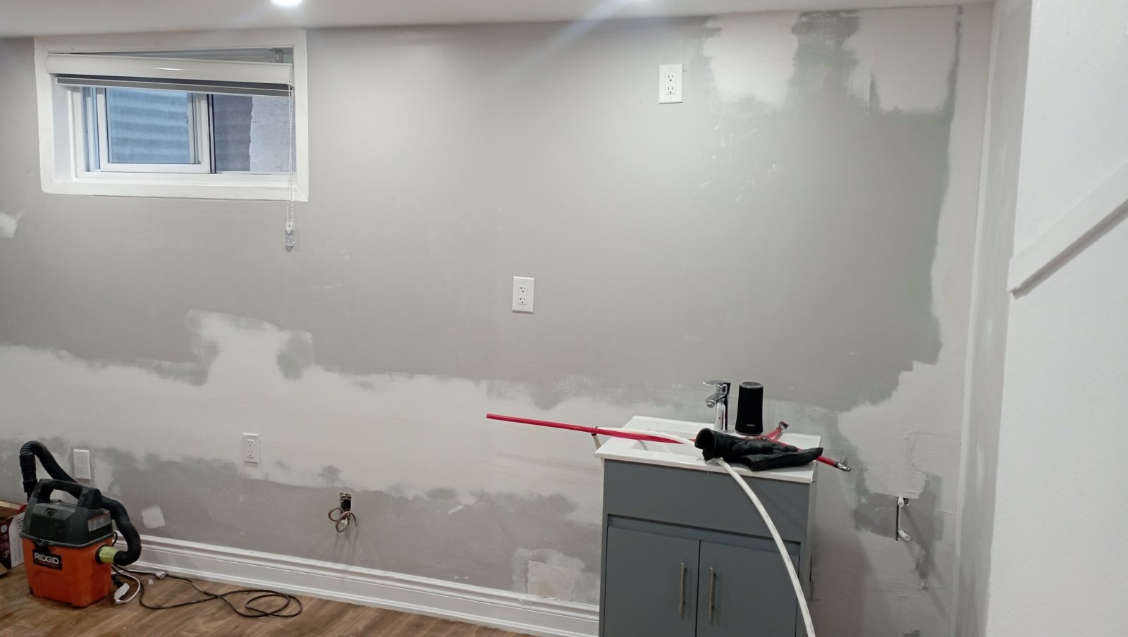 Basement wall with drywall mud applied around outlets and seams