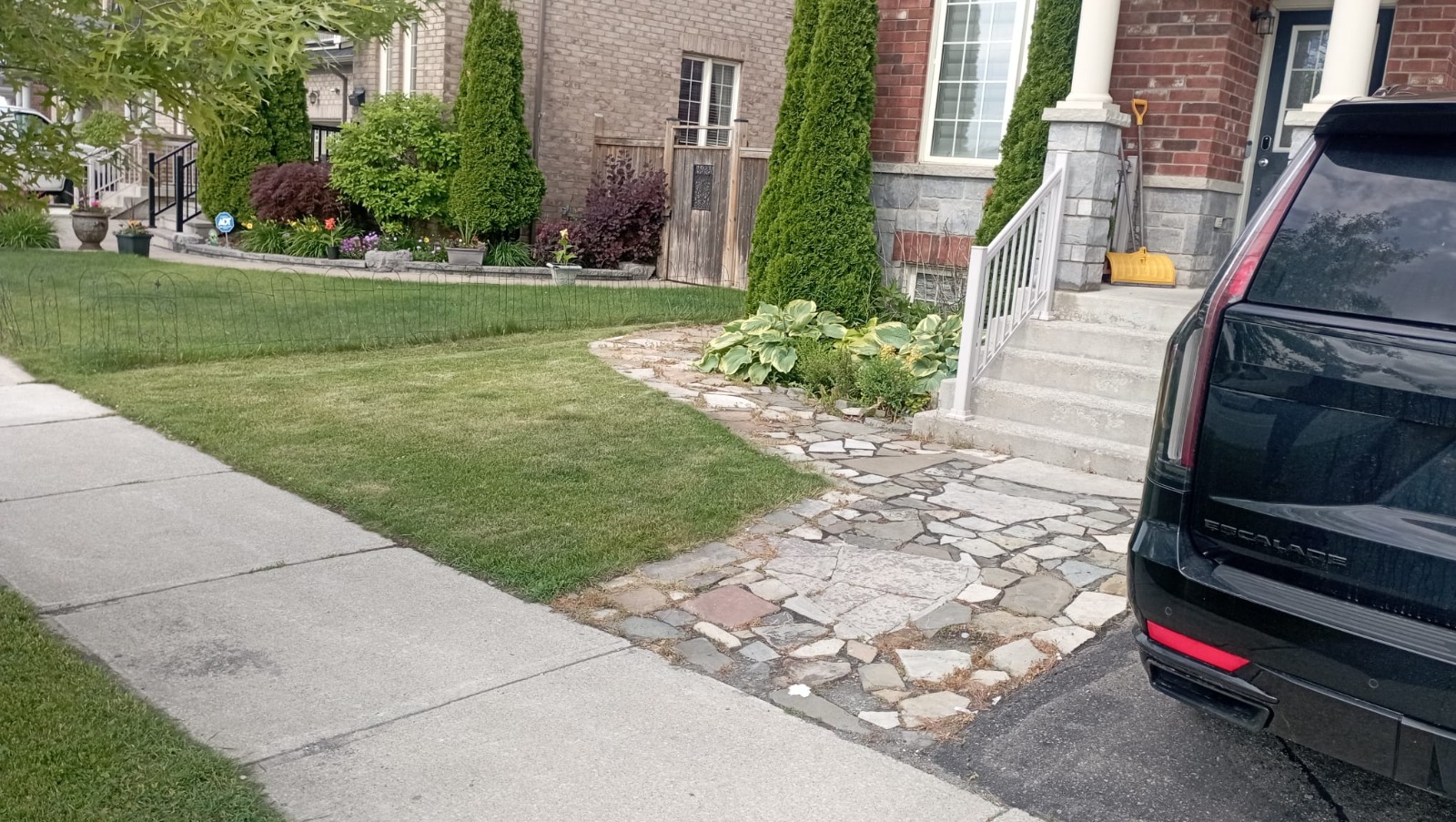 Front-yard flagstone walkway leading from sidewalk to porch with planted beds