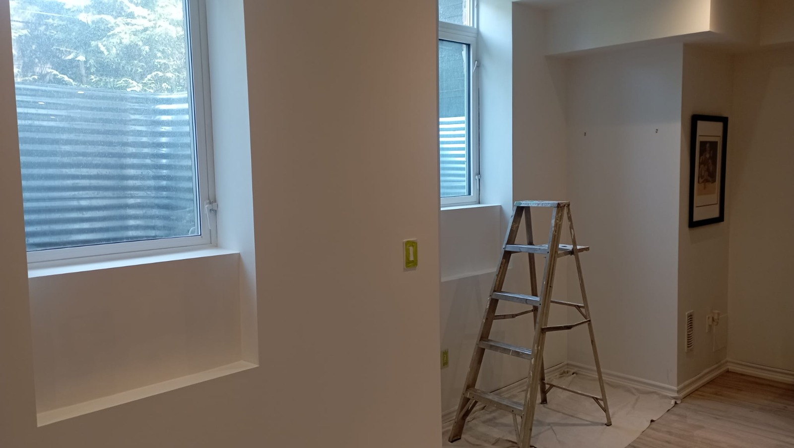 Basement bedroom freshly painted with drop cloths in place