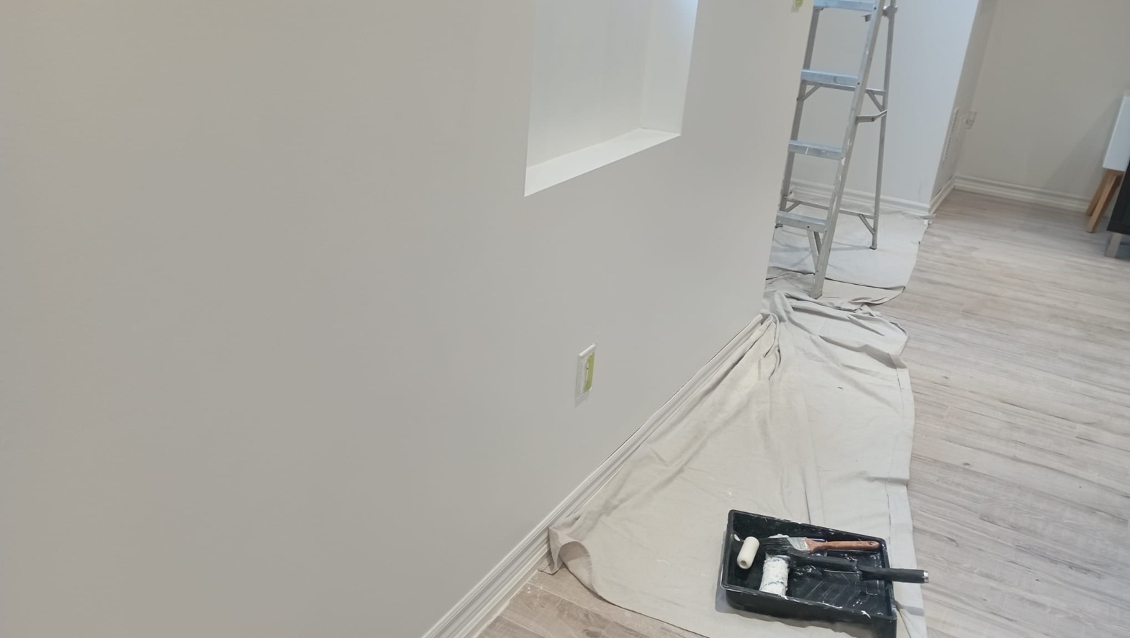 Freshly painted hallway with drop cloth and paint tray